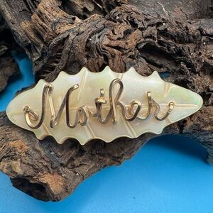 Vintage “Mother” brooch. Mother spelled out in gold tone on mother of pearl.